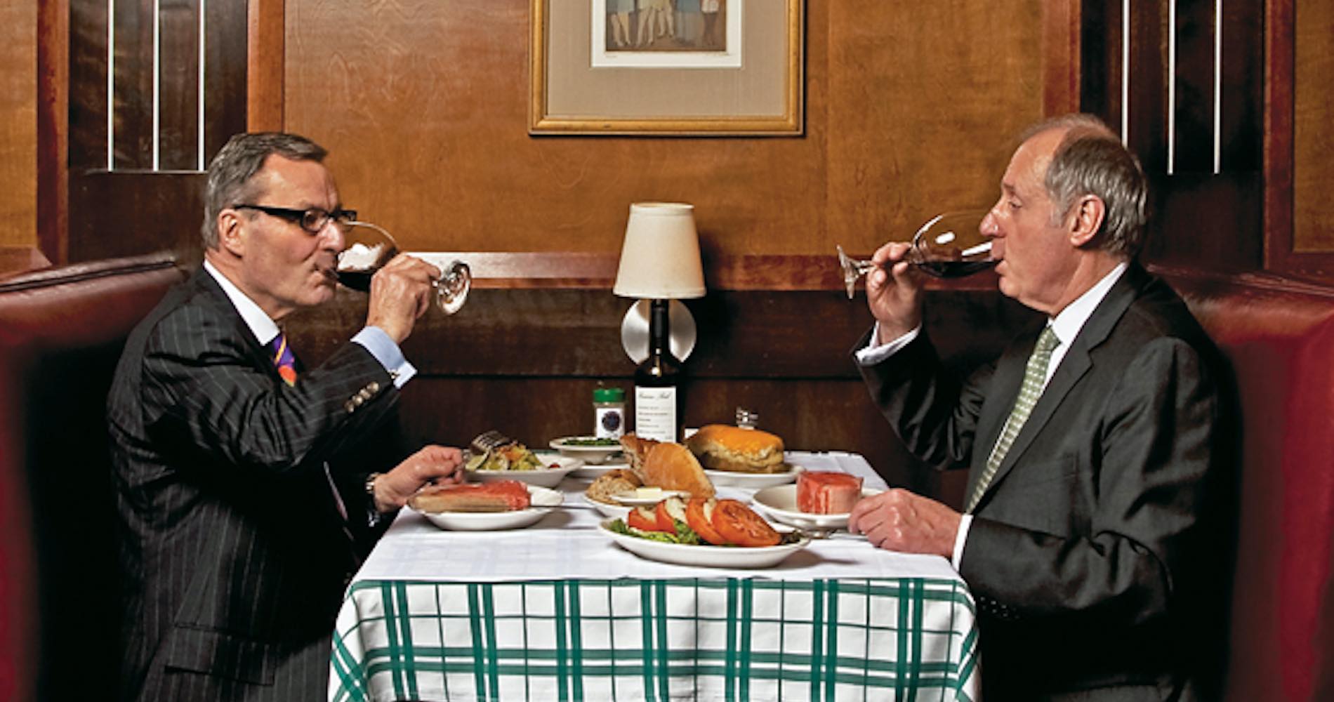about Photo of owners at a table drinking wine and with a full set table