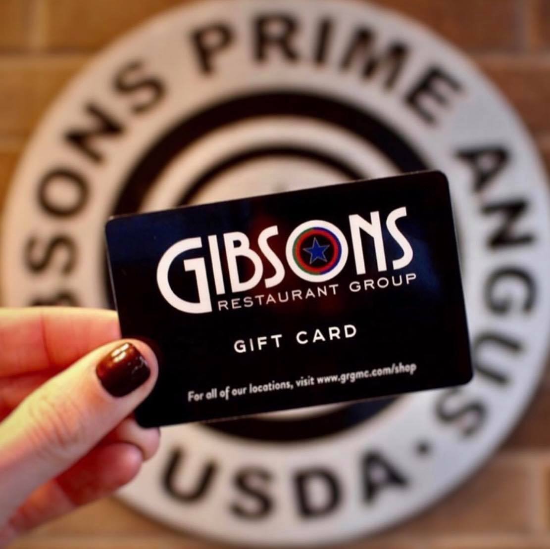 Image of a hand holding a Gibsons gift card